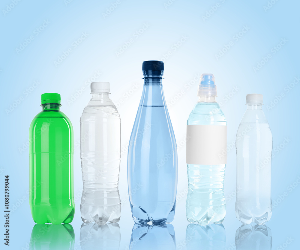 Different plastic bottles with water on light blue background Different plastic bottles with water on light blue background