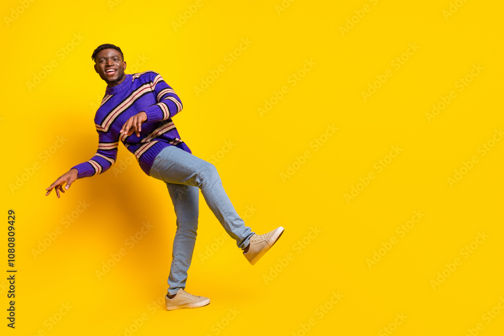 Full size photo of nice young man dance empty space advert isolated on yellow color background Full size photo of nice young man dance empty space advert isolated on yellow color background