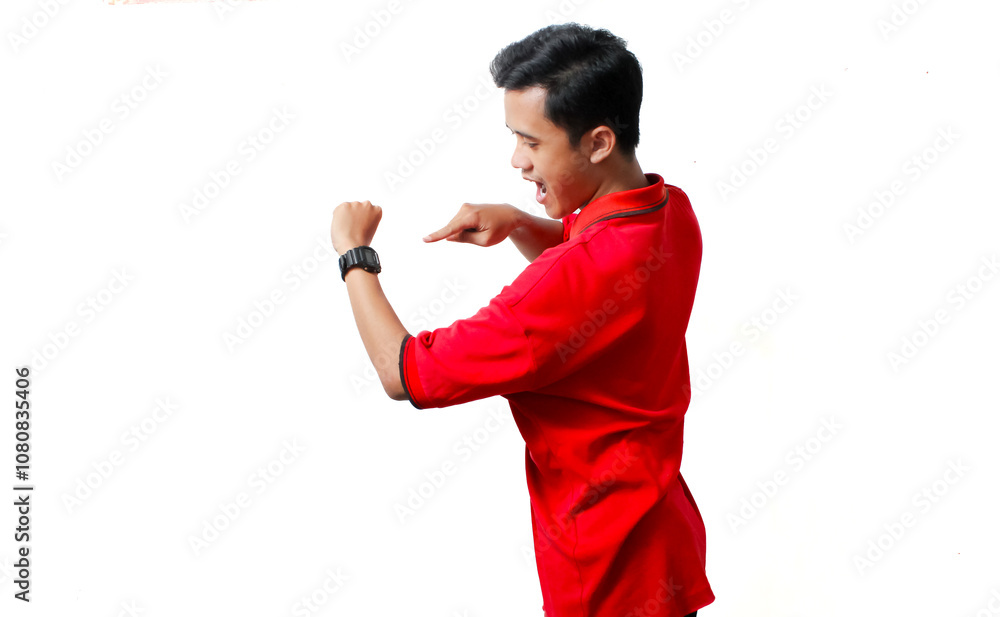 Asian man wearing red polo shirt showing digital watch with his finger, isolated white background.Telnology concept Asian man wearing red polo shirt showing digital watch with his finger, isolated white background.Telnology concept