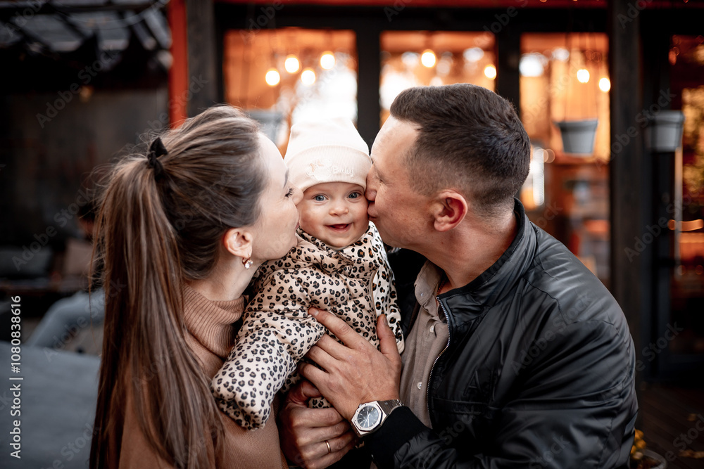 a young family with a small child in autumn in a cafe in brown and orange tones on an outdoor terrace hug and kiss, a happy family walks outside in autumn a young family with a small child in autumn in a cafe in brown and orange tones on an outdoor terrace hug and kiss, a happy family walks outside in autumn
