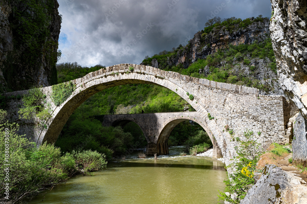 View of the traditional stone Bridge of Noutsos or Kokkoros in Epirus, Greece in Spring. View of the traditional stone Bridge of Noutsos or Kokkoros in Epirus, Greece in Spring.