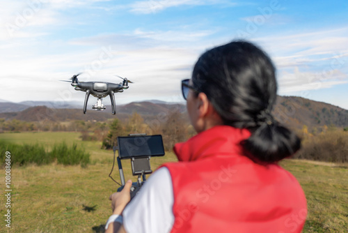 Obraz na płótnie A young woman controls a drone with a remote control in her hands. w salonie