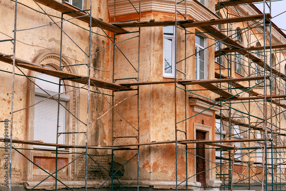 Obraz premium the building is under reconstruction, peeling walls and scaffolding around the building