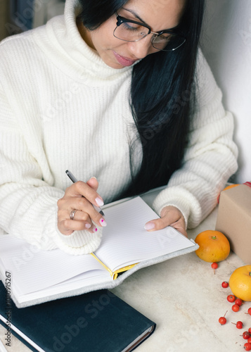 Festive Woman Writing Holiday Notes in Notebook