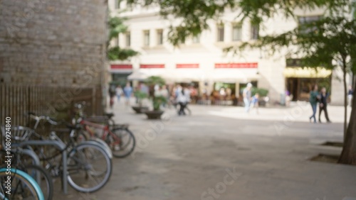 Blurred street scene in barcelona, spain, showcasing a defocused view of people and bicycles amidst an outdoor european setting with noticeable bokeh effect.