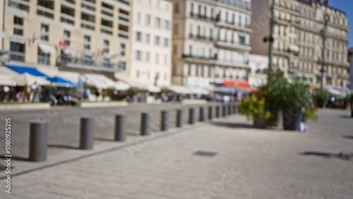 Blurred street scene in marseilles with buildings and pedestrians in the european outdoor setting, showcasing urban life with defocused elements and bright light.