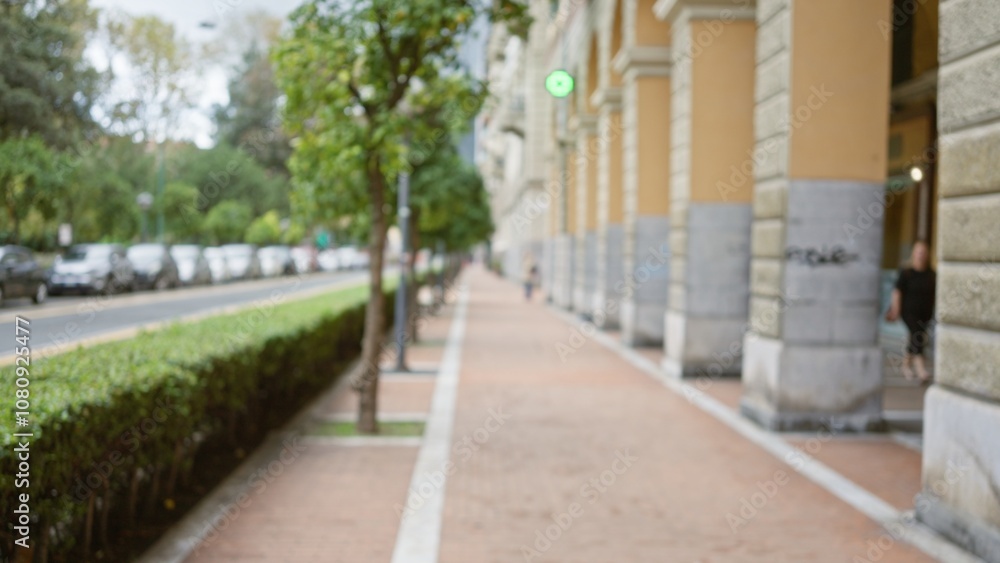 Blurred city street scene in la spezia, italy, featuring a woman walking on a sidewalk with trees, cars, and historic architecture in the background. Blurred city street scene in la spezia, italy, featuring a woman walking on a sidewalk with trees, cars, and historic architecture in the background.
