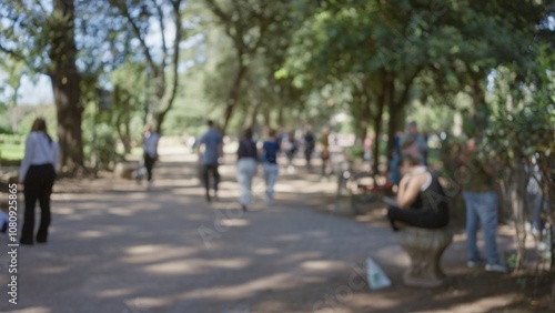 People walking in blurred villa borghese gardens with sunlight filtering through trees, featuring men and women in an outdoor setting in rome.