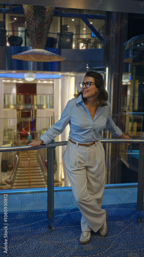 Woman smiling aboard luxury cruise, standing indoors in an elegantly designed hall, exuding relaxation and sophistication under warm lights, embodying style and modern travel. Woman smiling aboard luxury cruise, standing indoors in an elegantly designed hall, exuding relaxation and sophistication under warm lights, embodying style and modern travel.