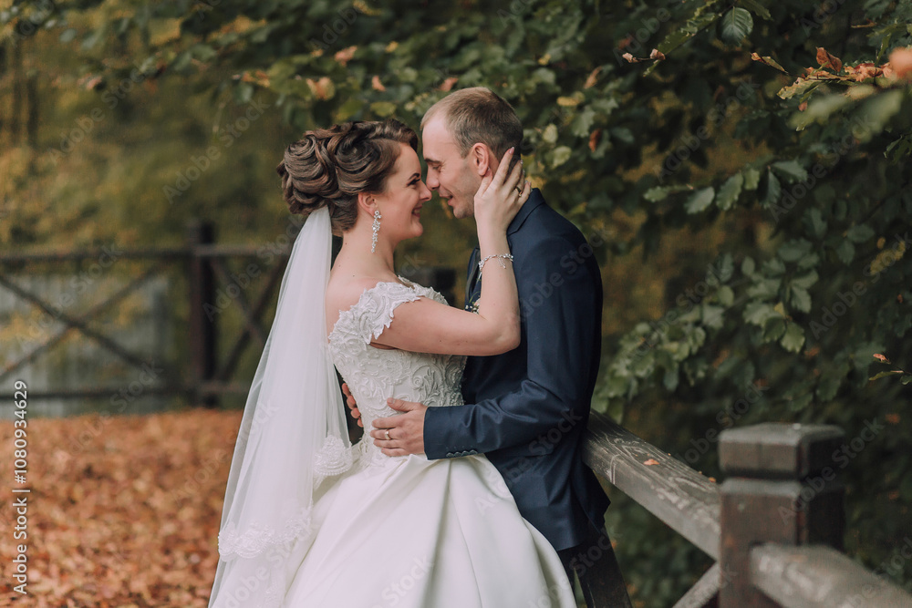 A bride and groom are hugging each other on a bridge. The bride is wearing a white dress and the groom is wearing a blue suit. Scene is happy and romantic A bride and groom are hugging each other on a bridge. The bride is wearing a white dress and the groom is wearing a blue suit. Scene is happy and romantic