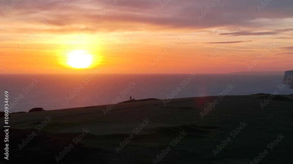 Sun is setting down in the sea and the view is captured from the top of the land of the island and people on that island enjoying the view Sun is setting down in the sea and the view is captured from the top of the land of the island and people on that island enjoying the view