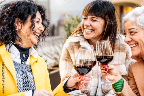 Genuine retired people having fun toasting and drinking red wine at dinner party at pub - Senior friends eating together outside at bar restaurant - Dining life style and friendship concept