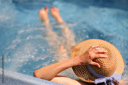 Obraz na plátne woman with hand on straw hat on head sitting inside the tub with massaging and r