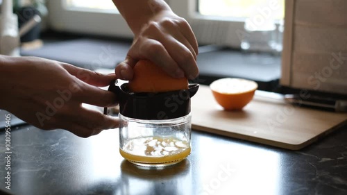 woman squeezing orange juice with a hand juicer