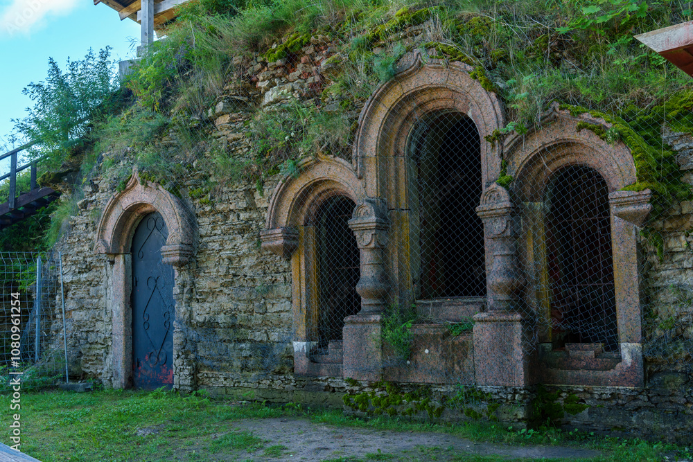 Ancient stone facade with arched windows and moss in historic fortress Ancient stone facade with arched windows and moss in historic fortress