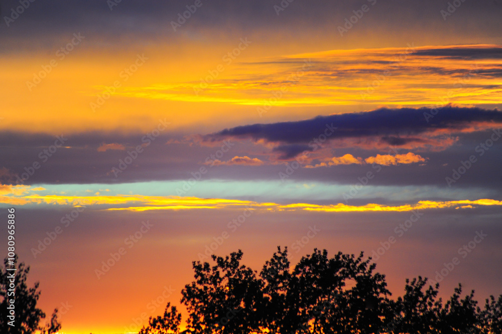 Obraz premium A beautiful house stands silhouetted against a stunning sunset sky 