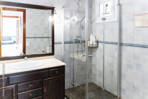 Elegant tiled bathroom with glass shower enclosure and vanity photo