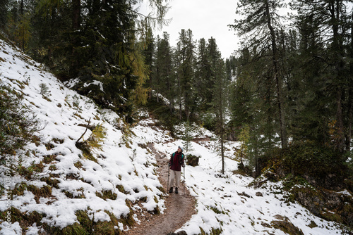 Hiker on snowy trail in Dolomites' Puez Geisler Natural Park photo