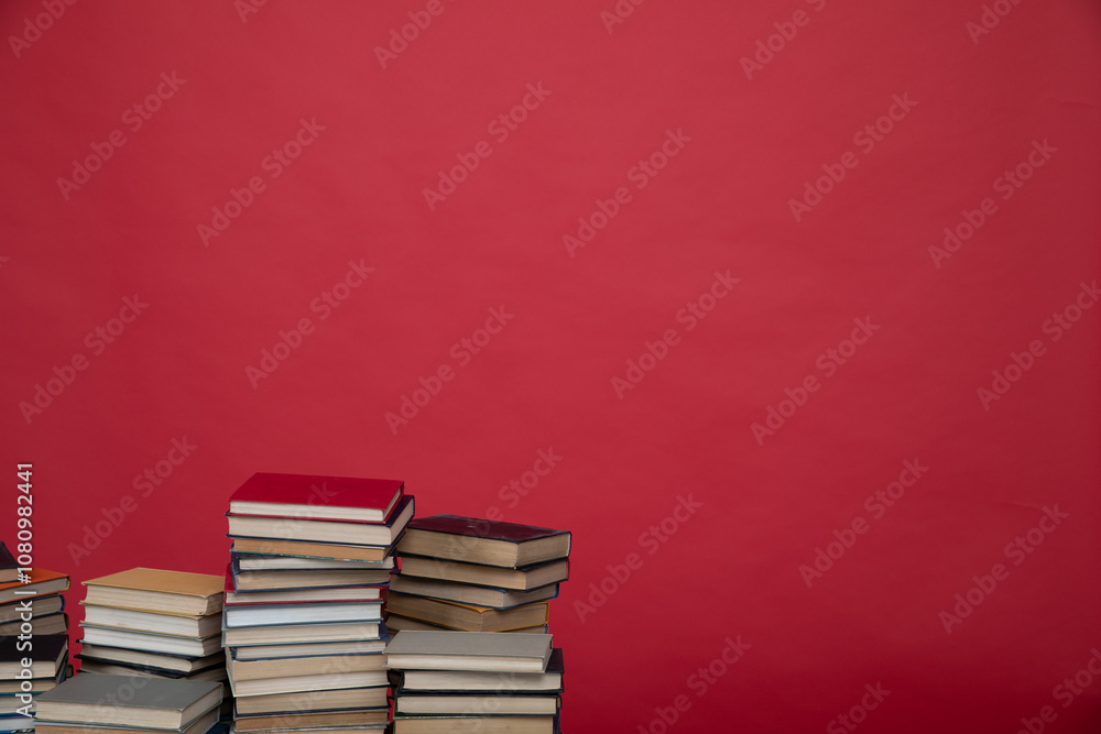 many stacks of educational books to study in the university library on a red background many stacks of educational books to study in the university library on a red background