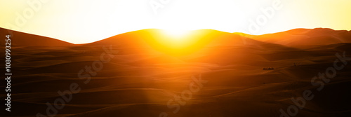 Sand dunes desert landscape at sunset, with camel and quadbike tours. Erg Chebbi. Merzouga. Sahara desert. Morocco. Africa.