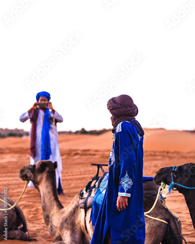 Camel guides in tuareg traditional clothing taking photograpphs with a cell phone. Erg Chebbi. Merzouga. Sahara desert. Morocco. North Africa photo