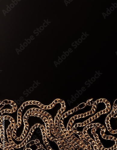 Gold chain that is laying on a black surface photo