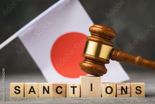 Judge gavel, wooden cubes with the text on the background of the Japanese flag, the concept on the theme of sanctions in Japan photo