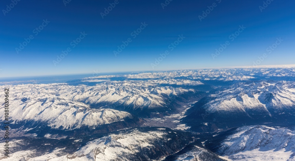 Obraz premium Majestic aerial view of -capped mountain range blue sky