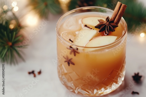 non alcoholic mulled apple cider in a glass with steam rising, garnished with star anise, cloves, and a cinnamon stick photo