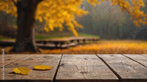 Obraz na płótnie Beautiful colorful natural autumn background for presentation. Fallen dry orange leaves on wooden boards against the backdrop of a blurry autumn park. w salonie