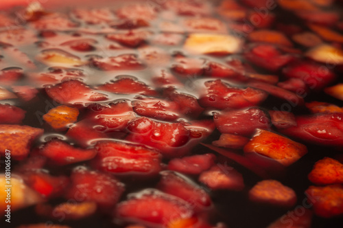 фотографія Red wine simmering with fruit in a pot on the stovetop