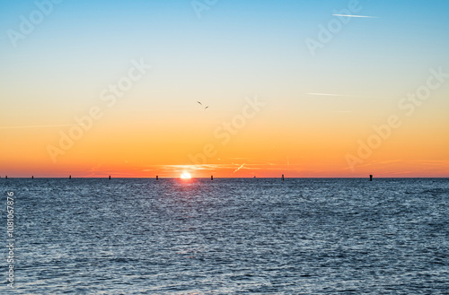 Fiery Sunset in Grado on the Sea in Winter: Light Trails and Birds in Flight Painting the Sky.