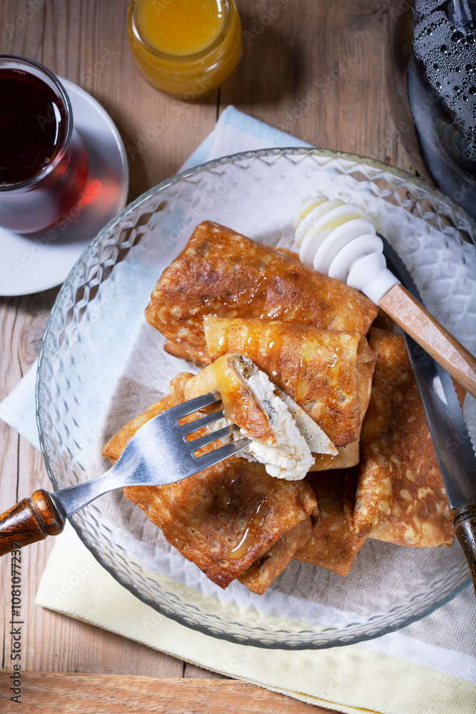 Pancakes with cottage cheese and raisin filling, served with honey and black tea. Traditional treat for Maslenitsa or Carnival.