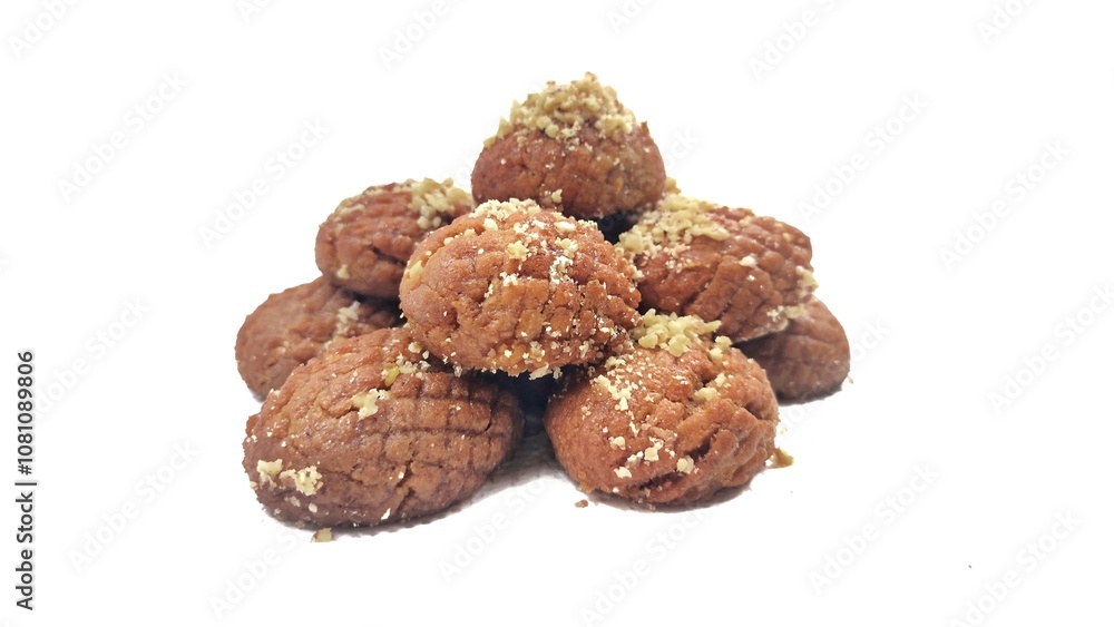 Photo of a pile of Greek melomakarona, traditional honey-soaked Christmas desserts topped with crushed walnuts, isolated against a white background. Photo of a pile of Greek melomakarona, traditional honey-soaked Christmas desserts topped with crushed walnuts, isolated against a white background.