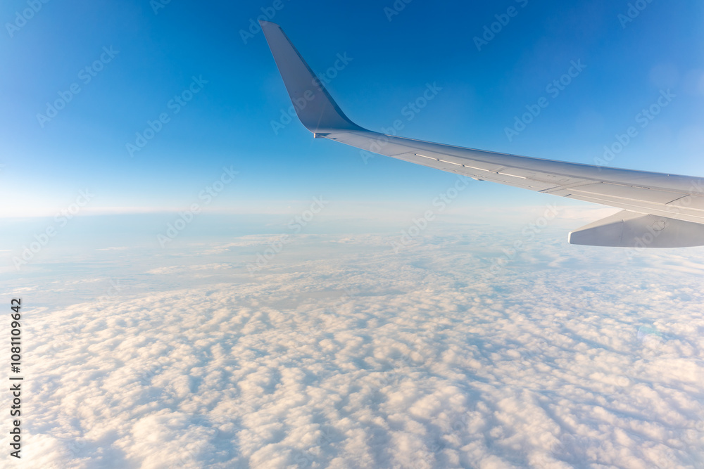 View from the airplane window at a beautiful cloudy sky and the airplane wing View from the airplane window at a beautiful cloudy sky and the airplane wing