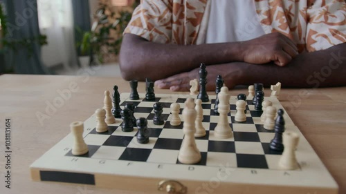 Close up view of hands of unrecognizable Black man moving pwn on chessboard during game