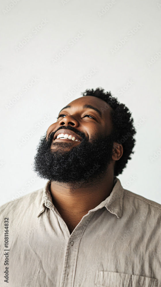 Happy african american man with a beard smiling and gazing upward in a joyful and positive portrait Happy african american man with a beard smiling and gazing upward in a joyful and positive portrait