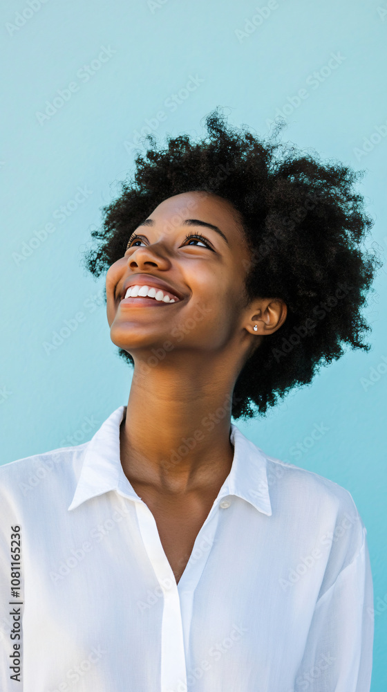 Portrait of a joyful and optimistic young black woman in a white shirt, gazing upwards in a studio setting Portrait of a joyful and optimistic young black woman in a white shirt, gazing upwards in a studio setting