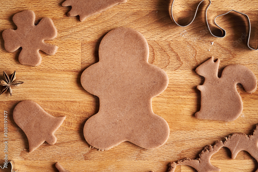 Gingerbread man cut our from raw pastry dough - preparation of Christmas cookies Gingerbread man cut our from raw pastry dough - preparation of Christmas cookies