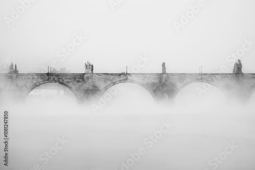 Charles bridge in Prague in the fog in the morning. Black and white. Vltava river
