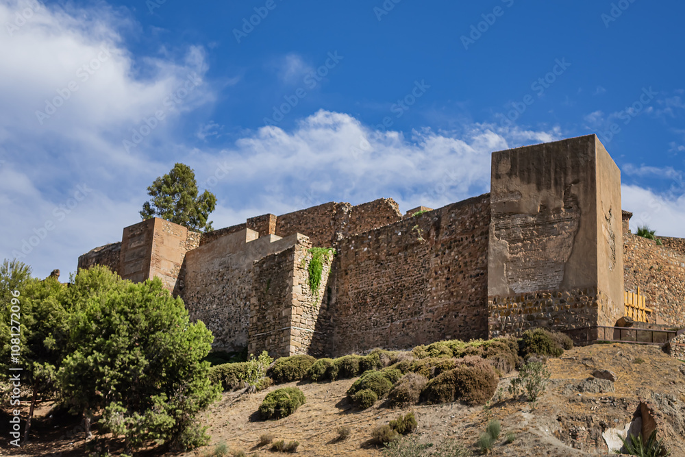 Scenic view of ancient ruins of Malaga Roman Theater (El Teatro Romano, I century BC) with historic Roman semi-circular seating at foot of famous Alcazaba fortress. Malaga, Andalusia, Spain. Scenic view of ancient ruins of Malaga Roman Theater (El Teatro Romano, I century BC) with historic Roman semi-circular seating at foot of famous Alcazaba fortress. Malaga, Andalusia, Spain.