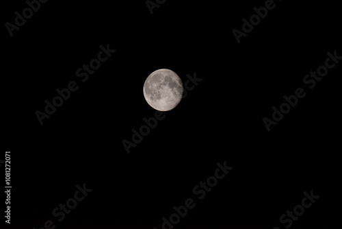 Close-up photograph of the waxing gibbous moon set against a black sky, showcasing detailed surface craters and texture. 