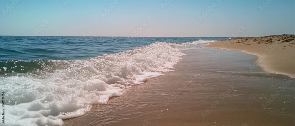Gentle waves kiss a sandy beach under a clear sky, invoking a sense of peace and summer's eternal charm. Gentle waves kiss a sandy beach under a clear sky, invoking a sense of peace and summer's eternal charm.