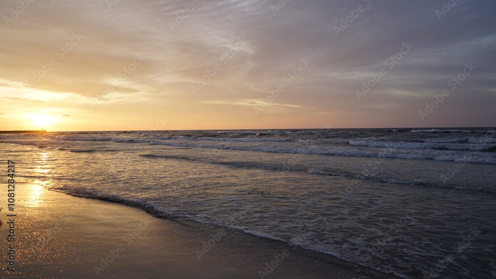 Obraz premium Sunset on the beach by the sea