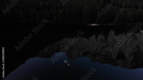 The fisherman in the boat on the green lake