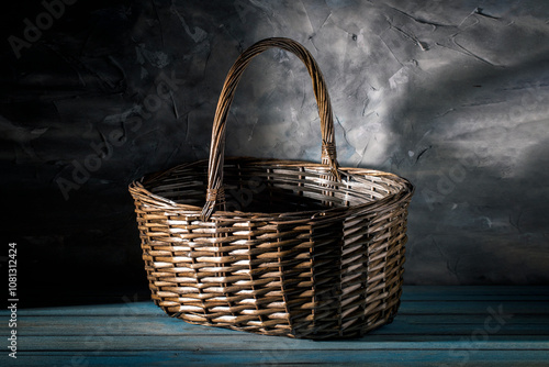 Wicker basket on blue wooden table against grey wall