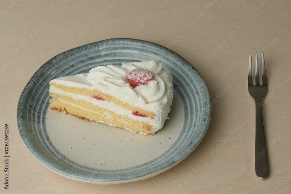 Japanese strawberry shortcake and fork on each stylish large and small plate on a wooden table Japanese strawberry shortcake and fork on each stylish large and small plate on a wooden table