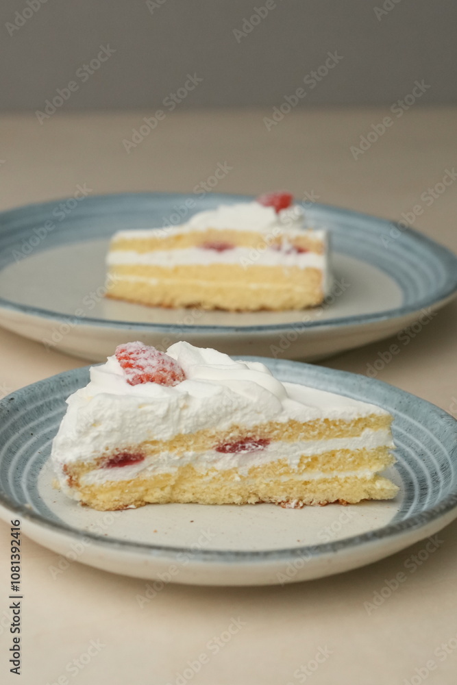 Japanese strawberry shortcake on each stylish large and small plate on a wooden table Japanese strawberry shortcake on each stylish large and small plate on a wooden table