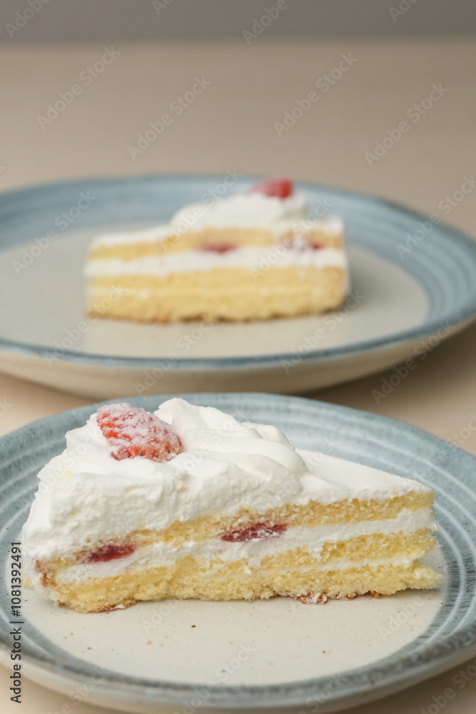 Japanese strawberry shortcake on each stylish large and small plate on a wooden table Japanese strawberry shortcake on each stylish large and small plate on a wooden table