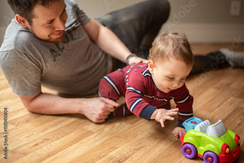 Baby plays with toy car with his dad